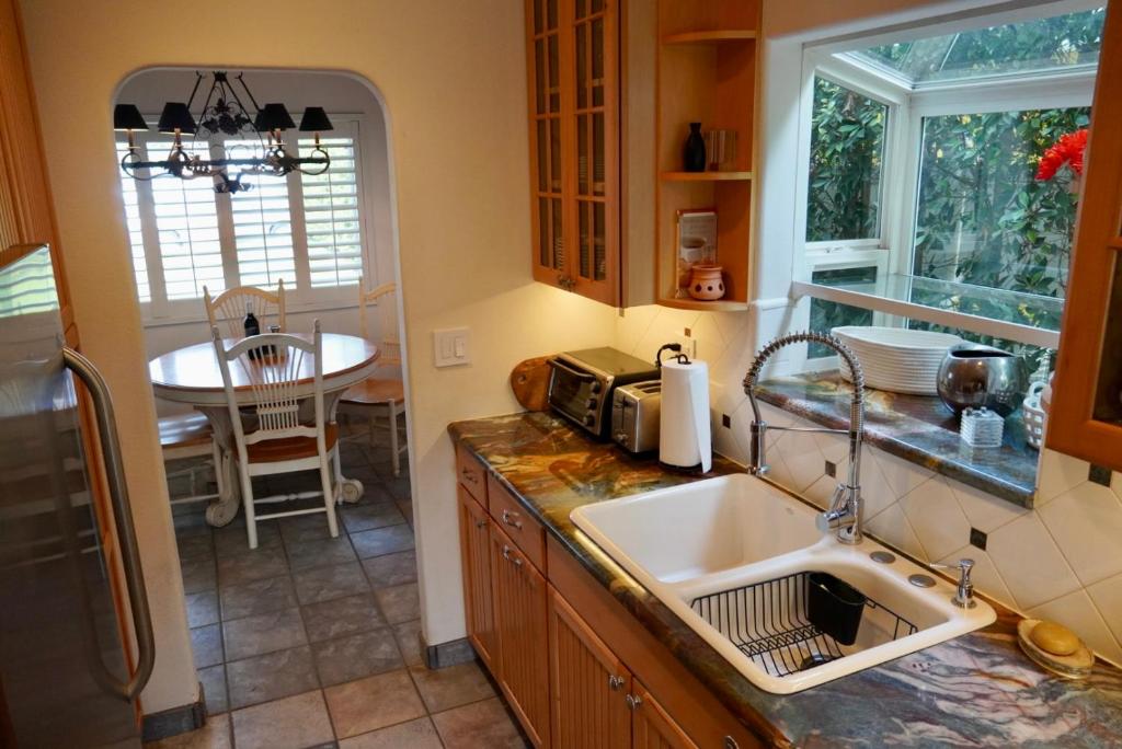 a kitchen with a sink and a table in it at Cozy Family Hideaway, sleeps 8, 4 tv's yard, shops in Simi Valley