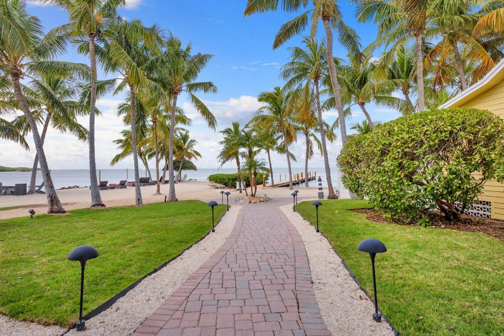 een loopbrug naast een strand met palmbomen bij Atlantic Bay Resort in Key Largo