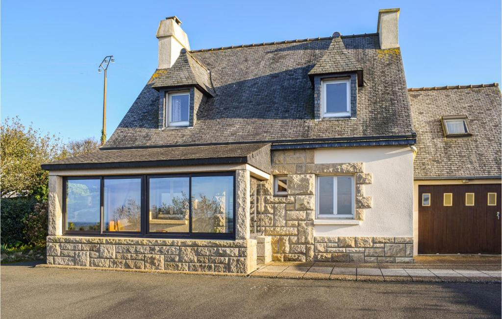 a stone house with large windows on a street at Amazing Home In Kerbors With Wifi And 3 Bedrooms in Kerbors