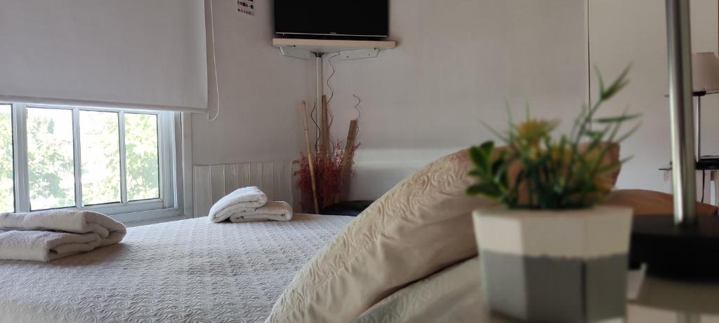 a bedroom with a bed with towels and a window at Canciller House Maipu in Maipú