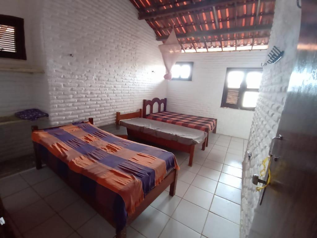 a bedroom with two beds and a couch in it at Casa de Praia, na Praia do Presídio in Aquiraz