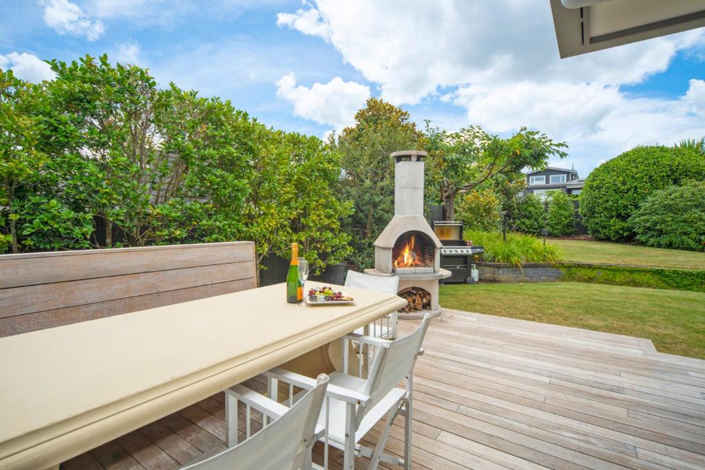 a patio with a table and chairs and a fireplace at Great Lake Getaway - Taupo in Taupo