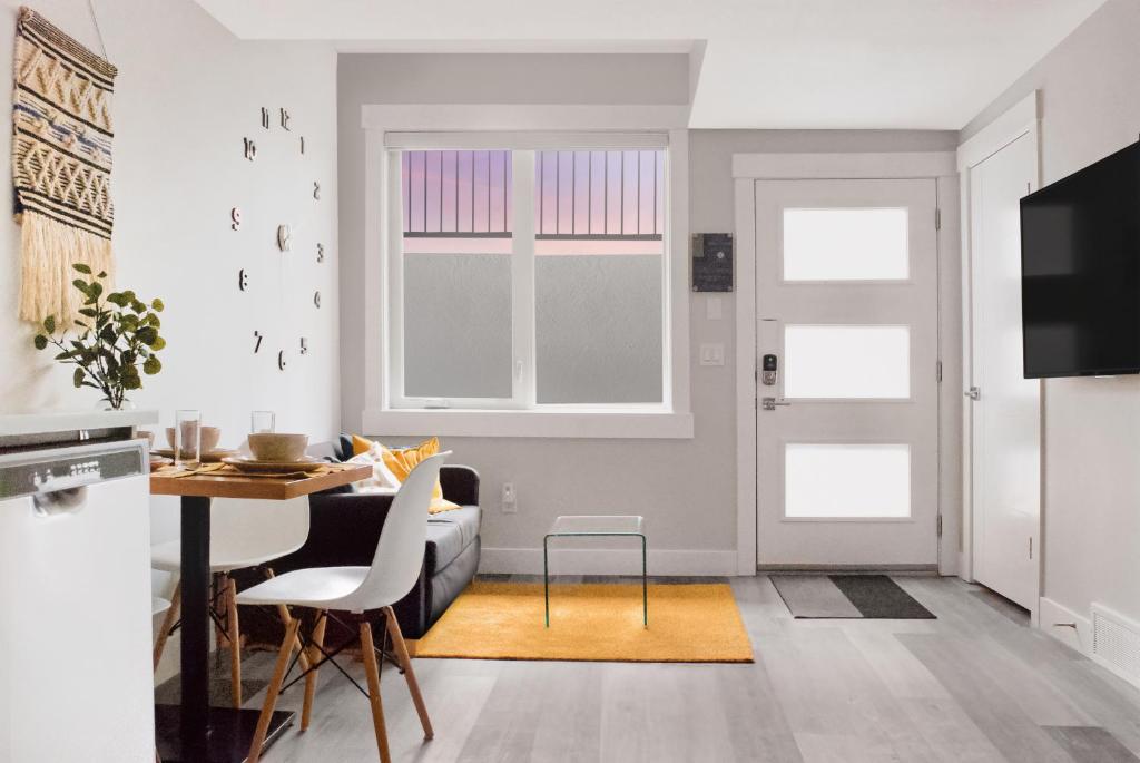 卡爾加里的住宿－Modern 1br Home Full Kitchen Smarttv，客厅配有桌椅和窗户。