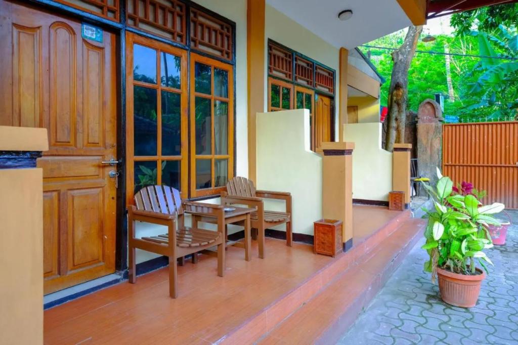 a porch of a house with a table and chairs at The Ellen Hotel by ecommerceloka in Senggigi