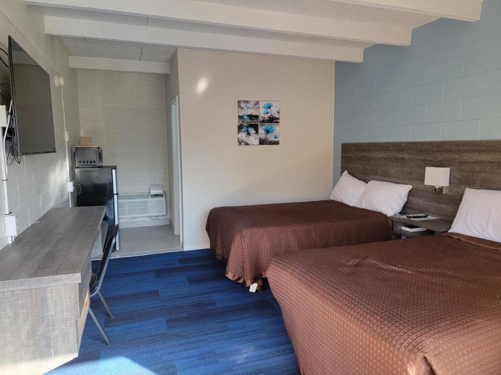 una camera d'albergo con due letti e una cucina di Budget Inn Winter Haven Auburndale a Winter Haven