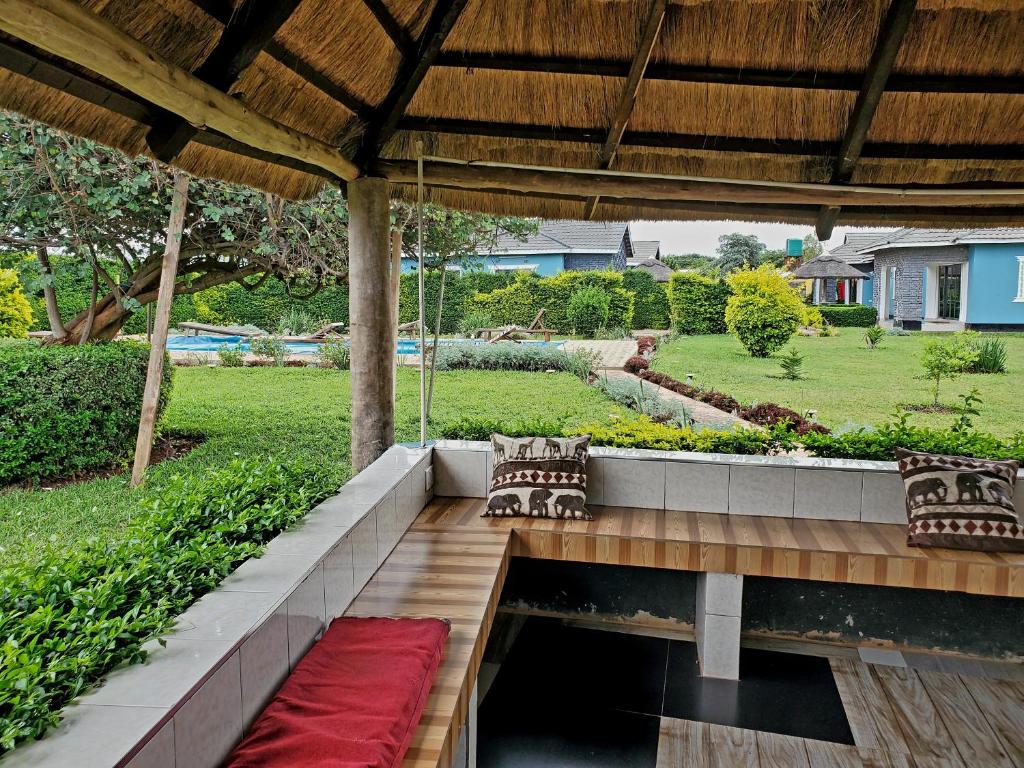 a patio with two benches and a red rug at Sweet Retreat in Lusaka