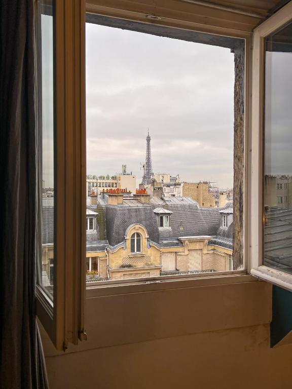 a window with a view of the eiffel tower at [New] Eiffel tower view studio &#47; Paris Étoile in Paris