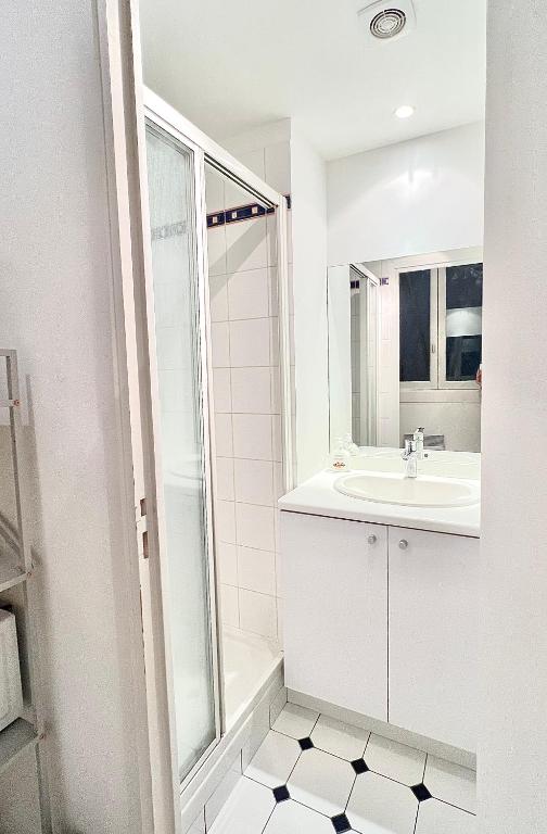 a white bathroom with a sink and a mirror at [New] Eiffel tower view studio &#47; Paris Étoile in Paris