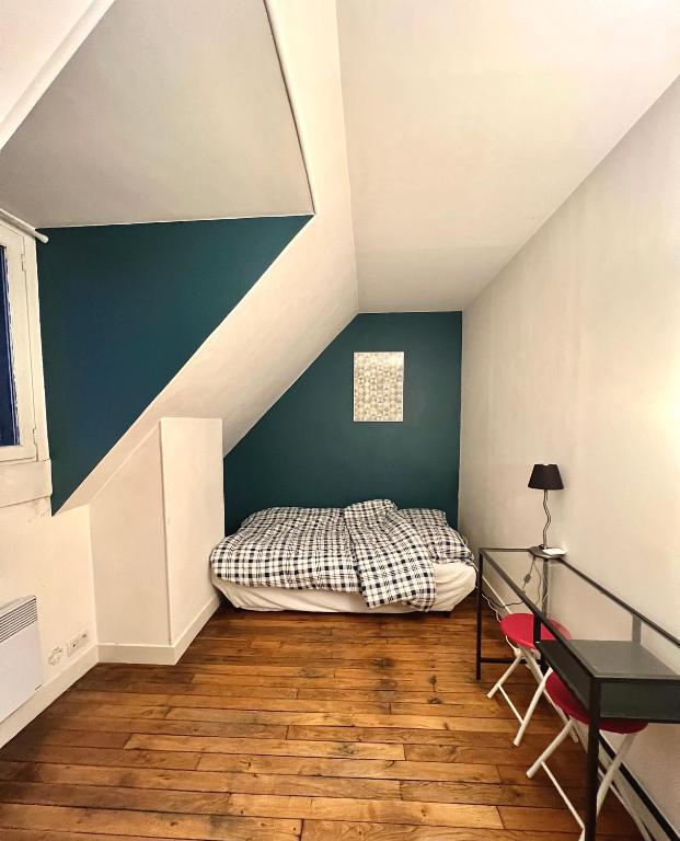 a bedroom with a bed and a blue wall at [New] Eiffel tower view studio &#47; Paris Étoile in Paris