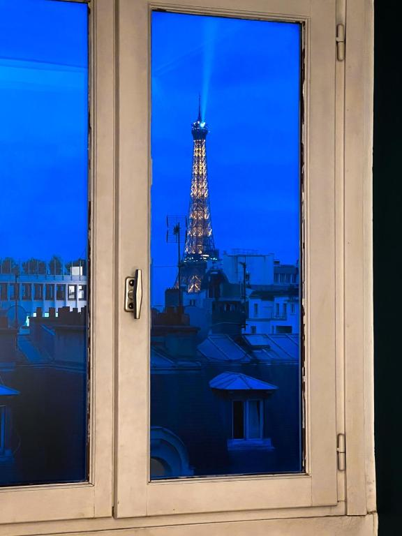 a view of the eiffel tower from a window at [New] Eiffel tower view studio &#47; Paris Étoile in Paris