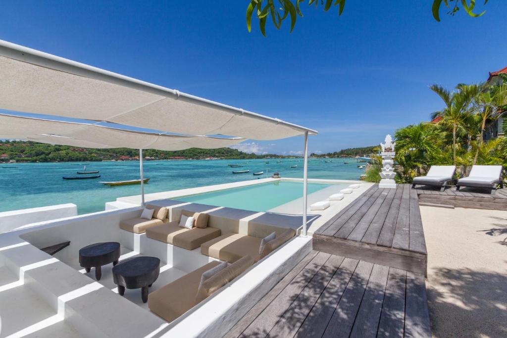 a villa with a swimming pool next to the ocean at Villa Lagoon - Elegant & Absolute BeachFront in Nusa Ceningan in Nusa Lembongan