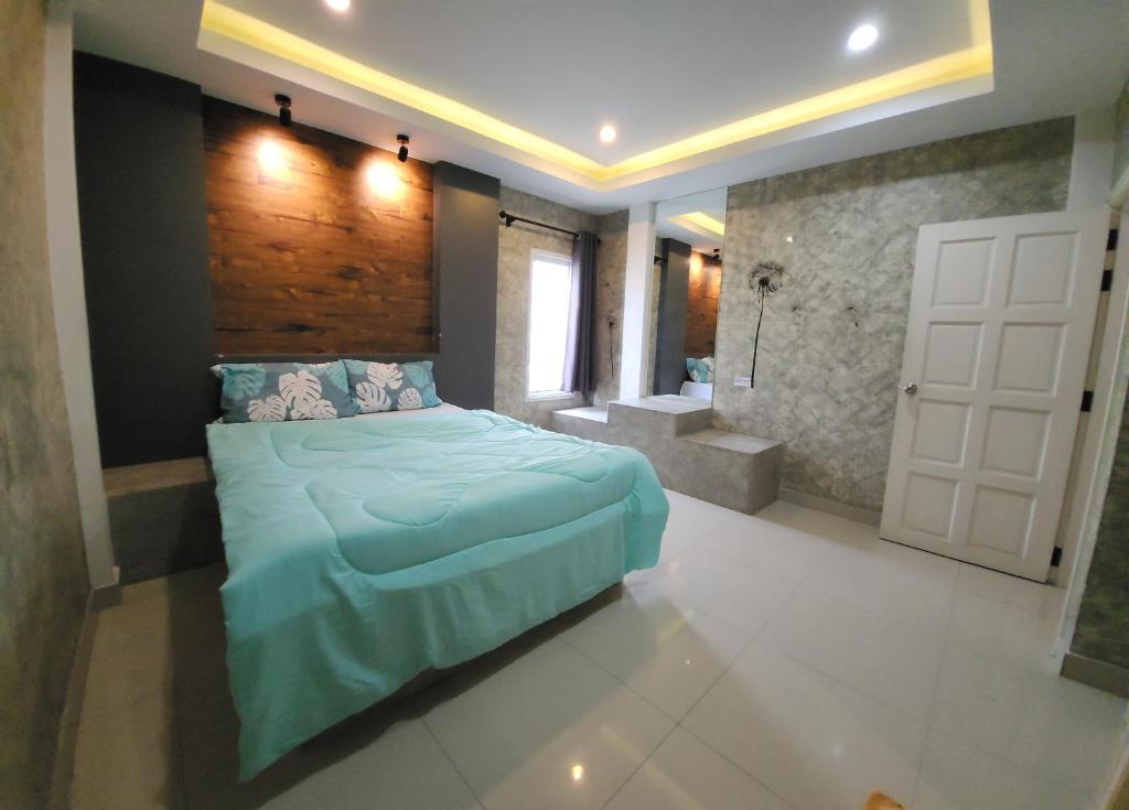 a bedroom with a blue bed and a bathroom at Loft House Resort Pattaya in Jomtien Beach