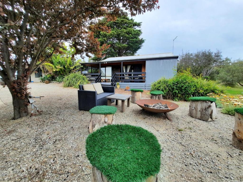 a backyard with a house with a table and chairs at The Beach Cabin in Fingal