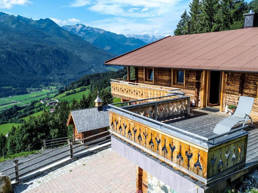 a house with a balcony with a view of mountains at Large hut in the Pinzgau with a great view and its own sauna hut in Dorf