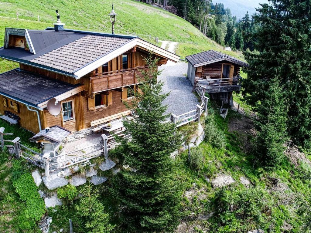 una vista aérea de una casa de madera en una colina en Cozy hut in Pinzgau with Finnish sauna en Dorf