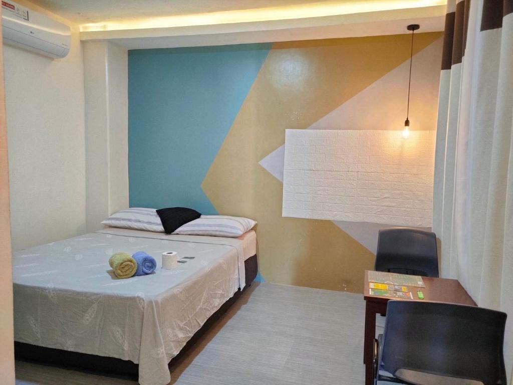 um pequeno quarto com uma cama, uma mesa e cadeiras em NINIE'S PLACE em Puerto Princesa