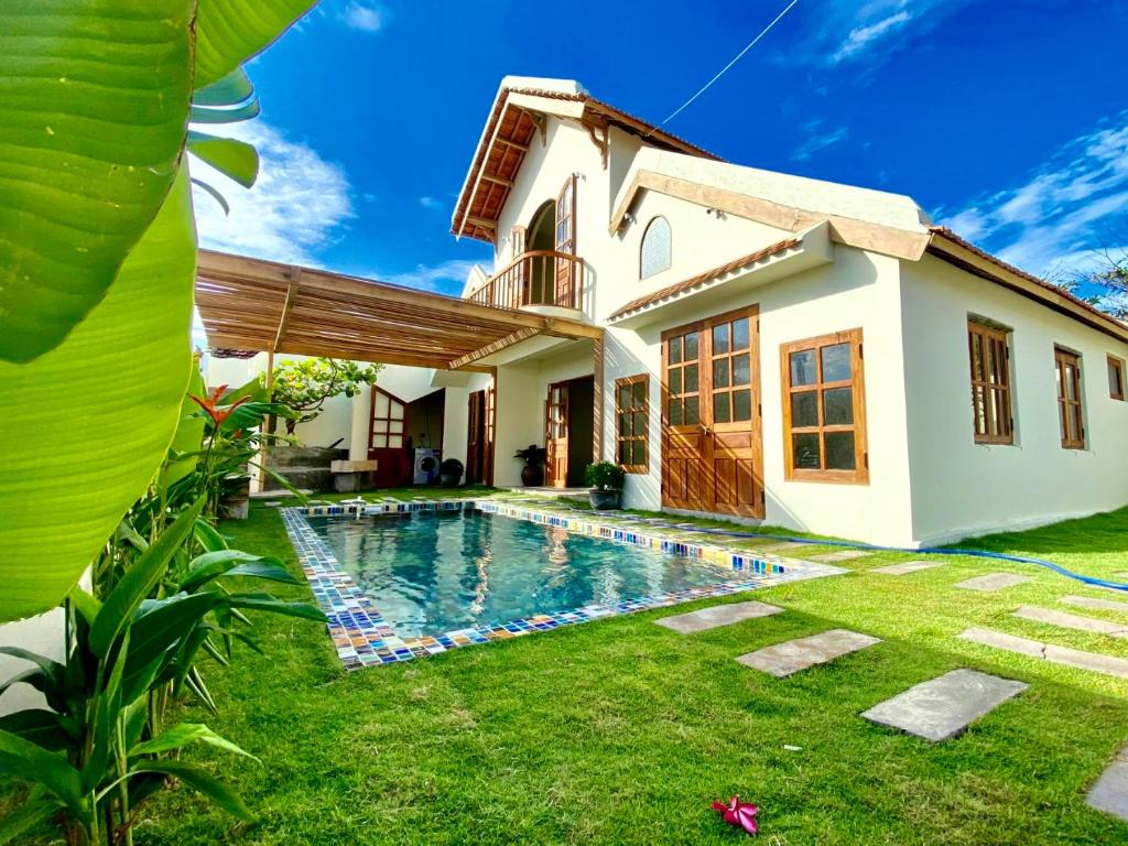 a house with a swimming pool in front of it at NGÀI Villa in Phu Yen