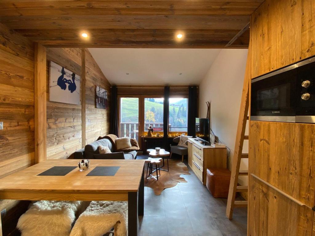un salon avec un canapé et une télévision dans l'établissement T2 avec Coin Nuit, Sud, Vue Montagnes, Wi-Fi, Non-Fumeur - FR-1-437-99, à La Clusaz