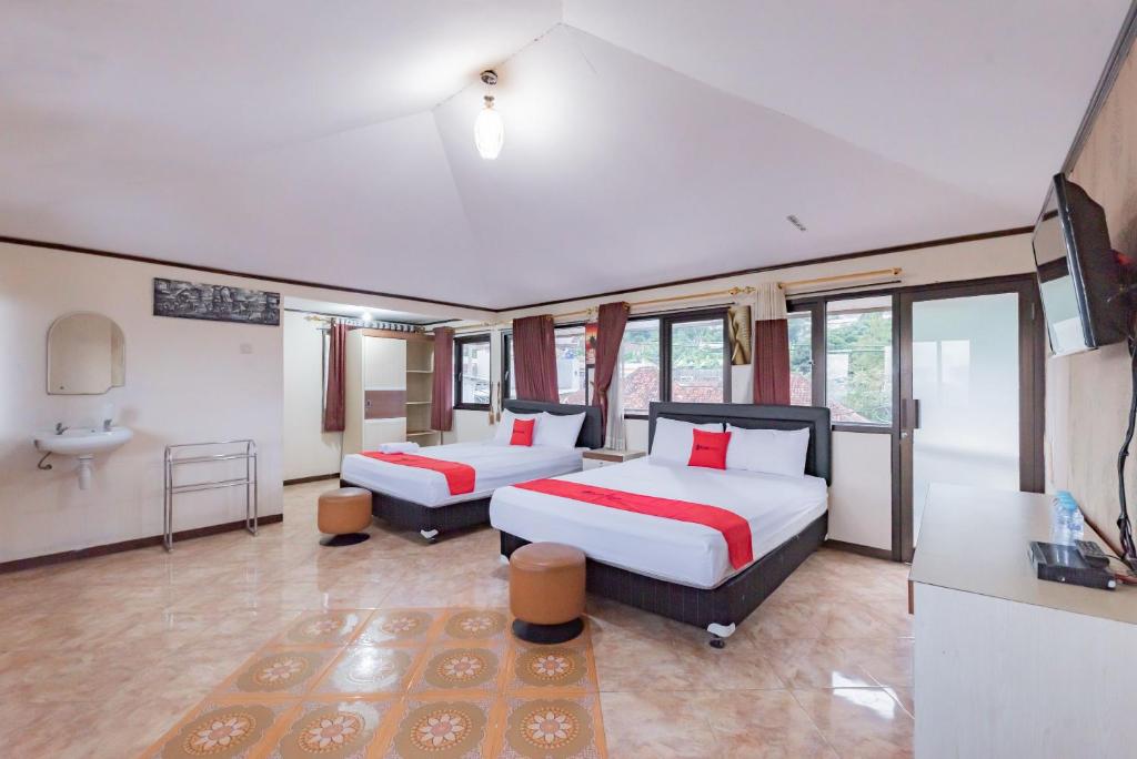 a hotel room with two beds and a bathroom at RedDoorz near Cikole Lembang in Lembang