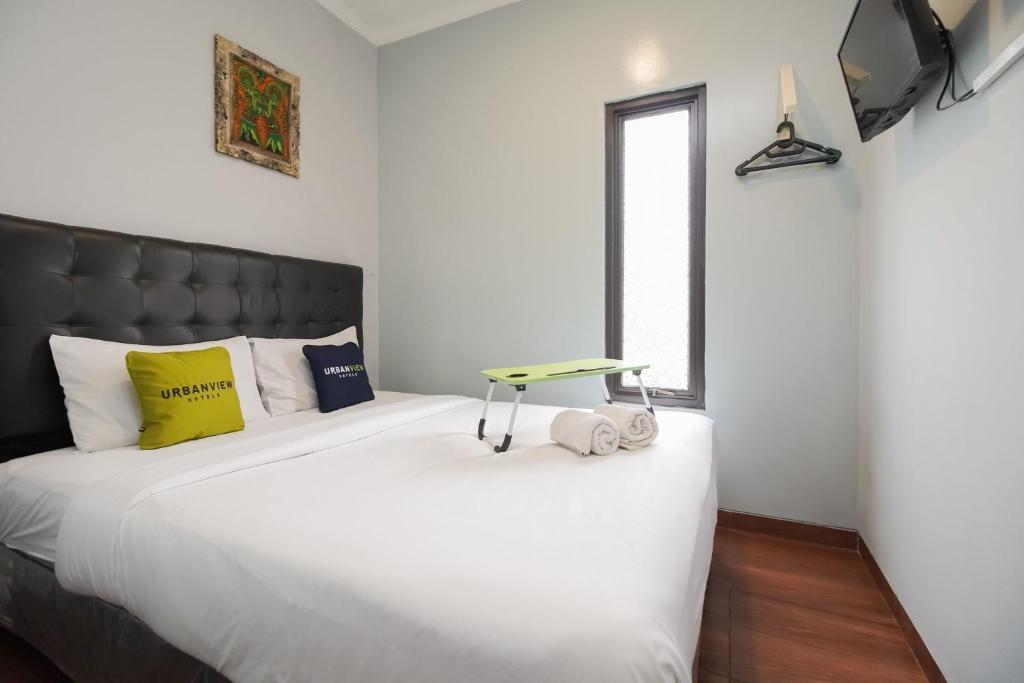 Un pat sau paturi într-o cameră la Urbanview Hotel Arafuru Residence Duren Sawit