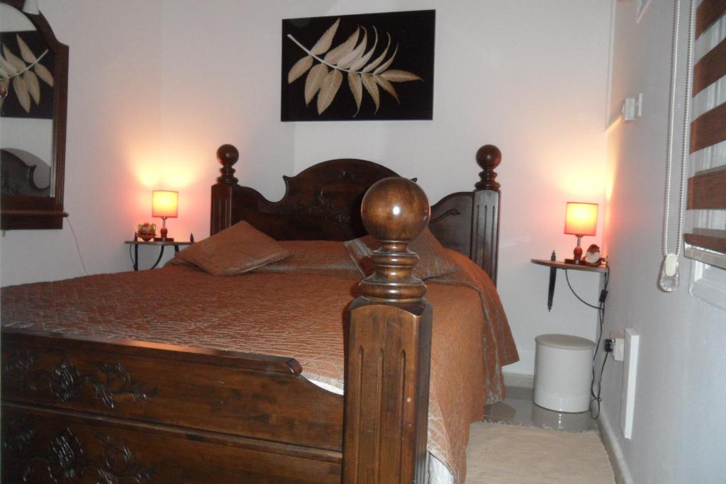 - une chambre avec un lit en bois et 2 lampes dans l'établissement Apartment Ground Floor, FREE INTERNET, à Ayia Napa