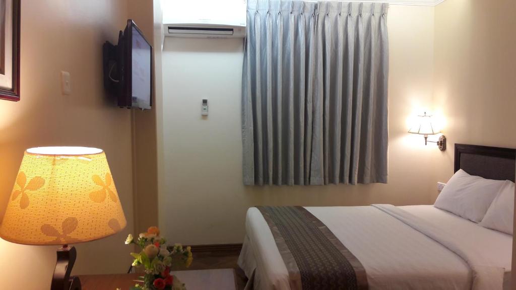 Postel nebo postele na pokoji v ubytování Grand Laurel Hotel