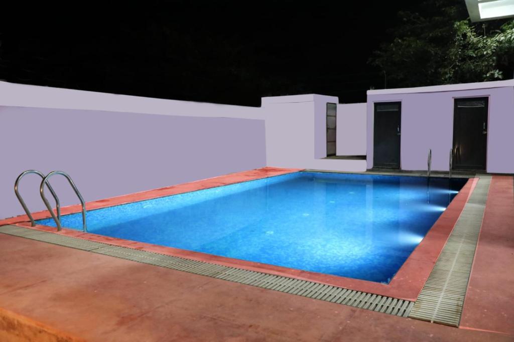 a swimming pool in a backyard at night at The Forest View Resort in Khilchipur