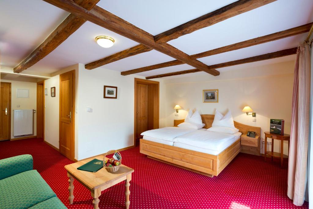 a bedroom with a bed and a couch and a table at Murhof Hotel in Frohnleiten