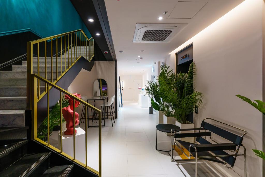 a hallway with chairs and stairs in a building at Yangju Hotel Ippda in Yangju