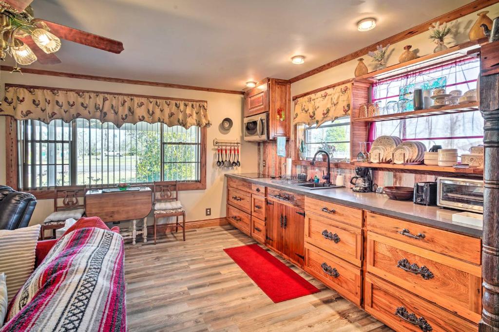 a kitchen with wooden cabinets and wooden floors and windows at Cozy Lake Charles Studio with Golf Course Views in Lake Charles