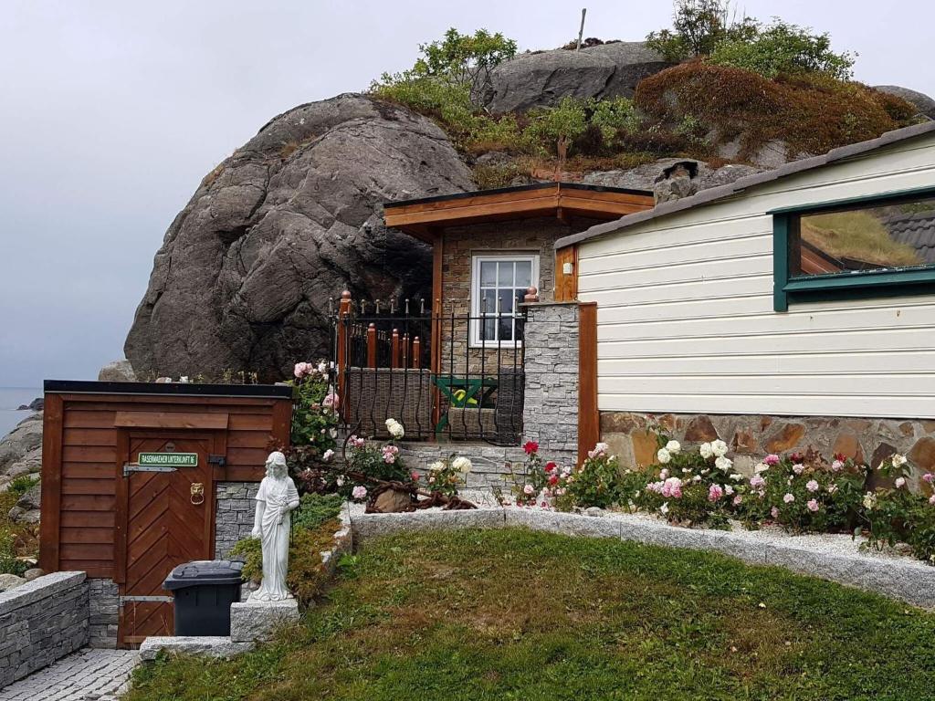une maison avec une statue en face d'une montagne dans l'établissement Holiday home skudeneshavn II, à Skudeneshavn