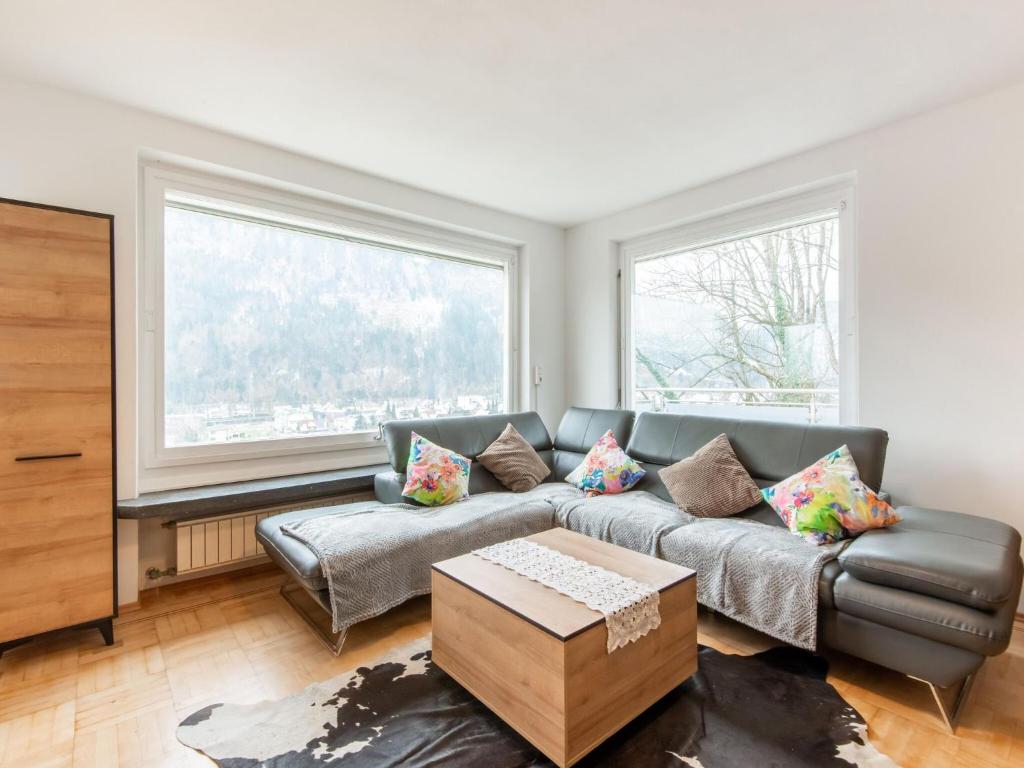 a living room with a couch and two windows at Beautiful Holiday Home in Feldkirch with Garden in Feldkirch