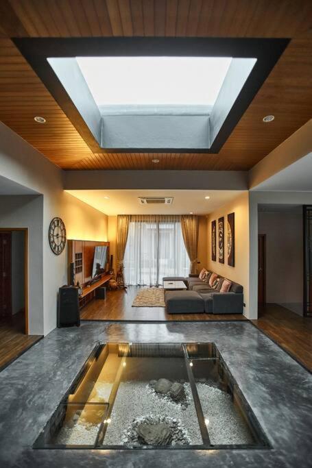 a living room with a pool in the middle of the room at Baan Bua BT17 by Villacarte in Nai Harn Beach