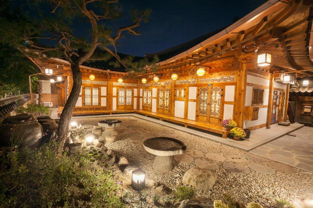 un edificio con un patio con un árbol y luces en Samlockhon Hanokstay en Jeonju