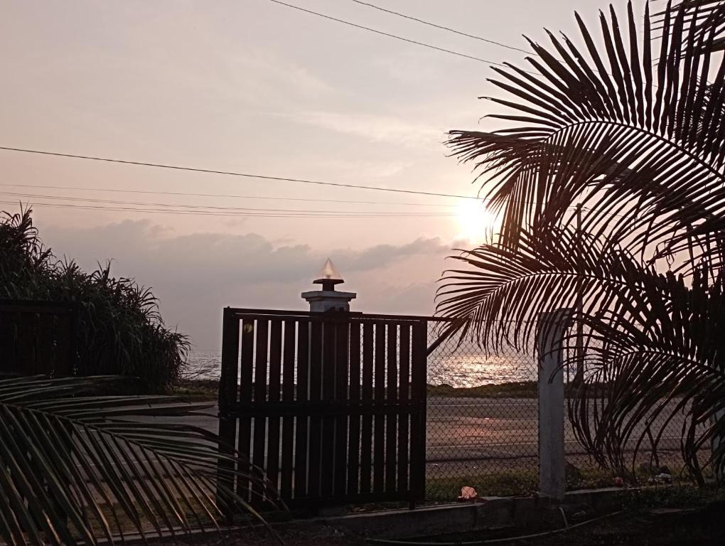 a gate with a lighthouse in front of the ocean at Surf Forever in Midigama
