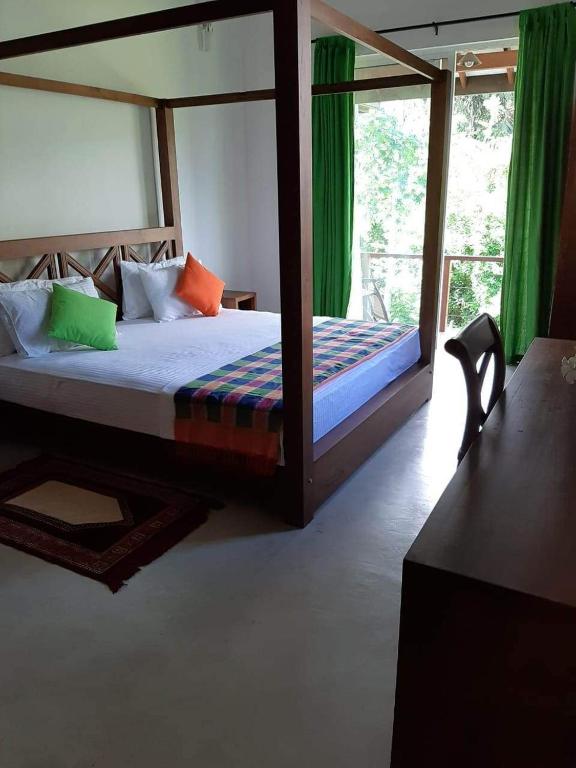 una camera da letto con un grande letto con tende verdi di Victoria Views Resort Kandy a Digana