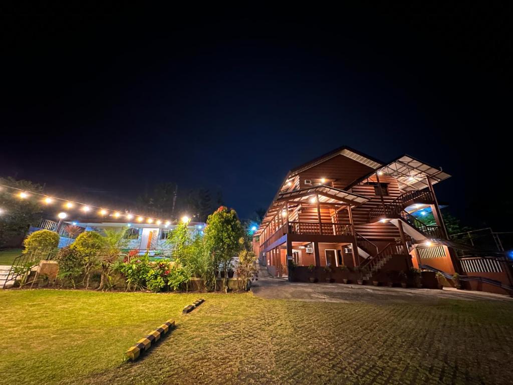 Piña Colina Resort في تاجيتاي: منزل خشبي عليه أضواء في الليل