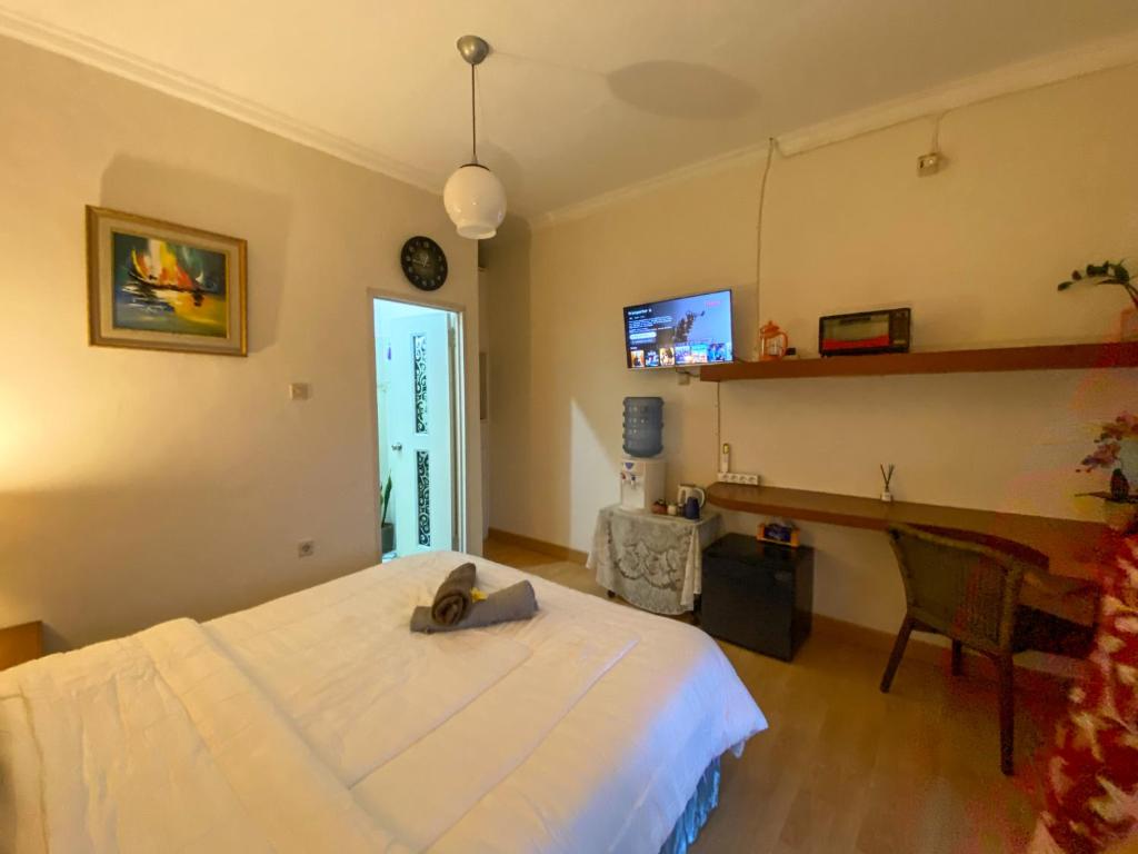 sypialnia z łóżkiem, biurkiem i telewizorem w obiekcie Kost Studio 62 w mieście Depok