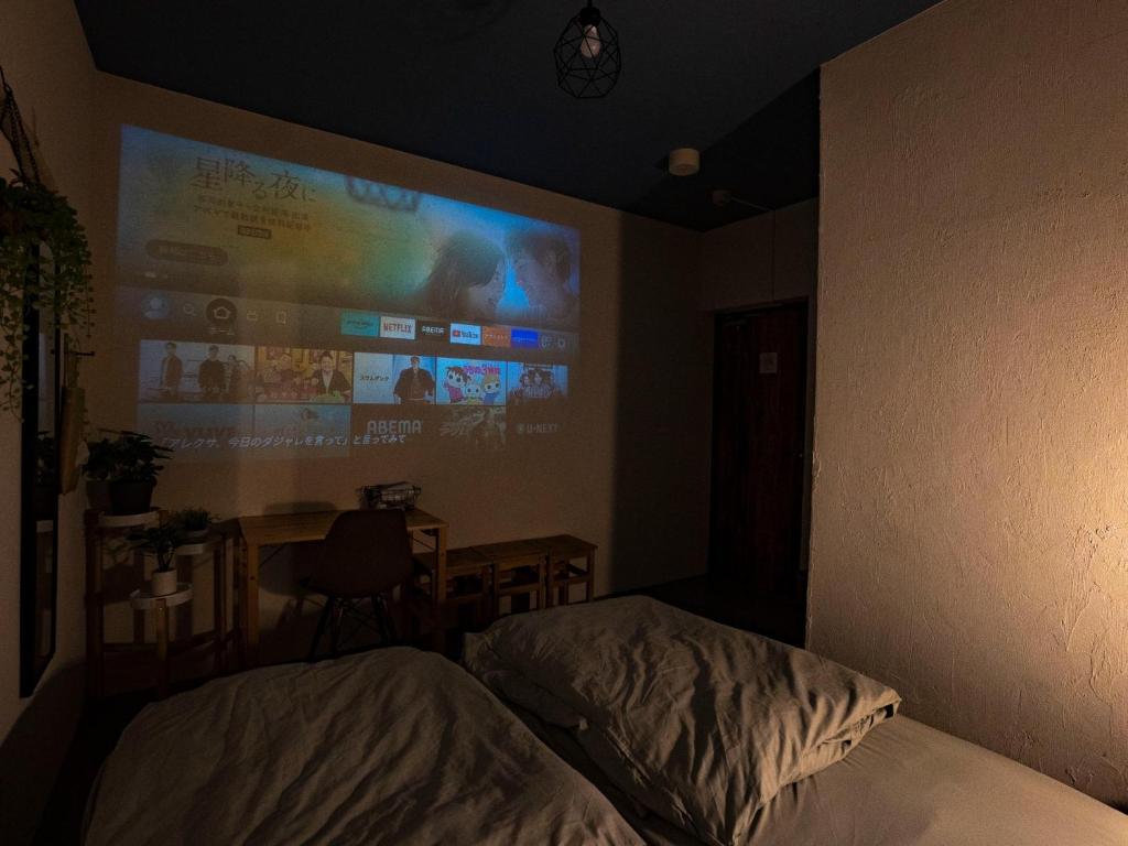 1 dormitorio con pantalla de proyección en la pared en We Home-Hostel & Kitchen- - Vacation STAY 30096v, en Ichikawa