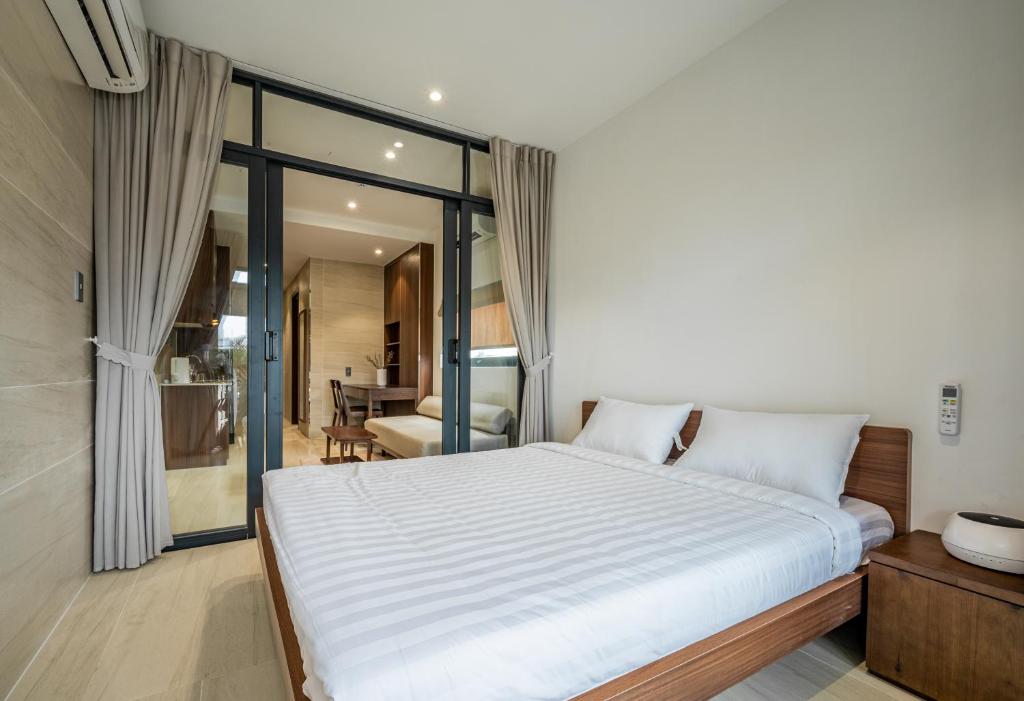 une chambre avec un grand lit blanc et une salle de bain dans l'établissement Stockholm Apartment, à Hô-Chi-Minh-Ville