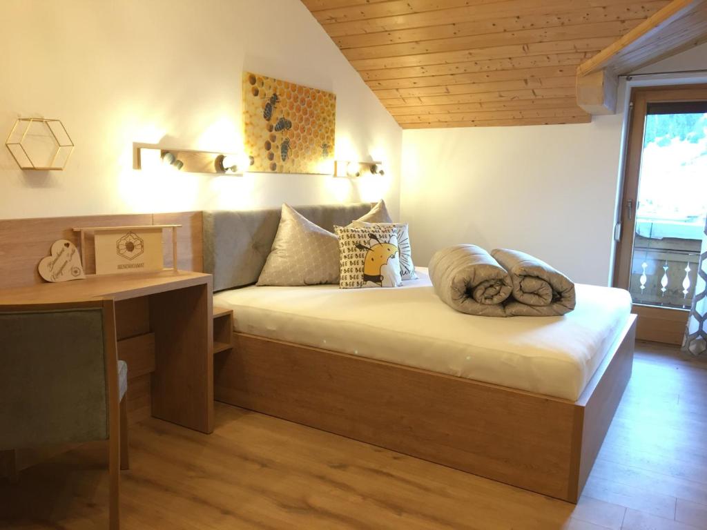 een slaapkamer met een bed en een bureau in een kamer bij Haus BIENENHOAMAT in Nauders