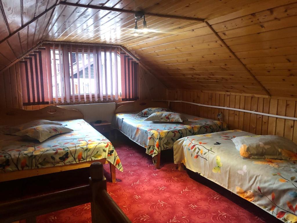 um quarto com 2 camas num chalé de madeira em Casa de vacanța Cristina em Cîmpu lui Neag