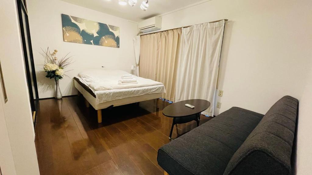 a small room with a bed and a table at Ogi-Ohashi Apartment in Tokyo