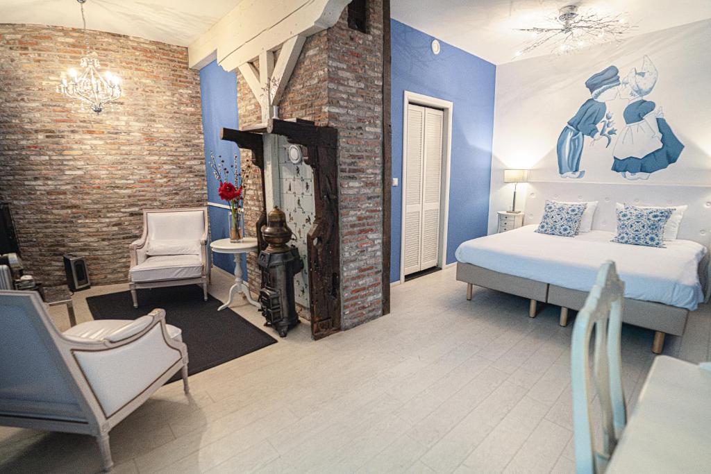 a bedroom with a bed and a brick wall at Hotel Johannes Vermeer Delft in Delft