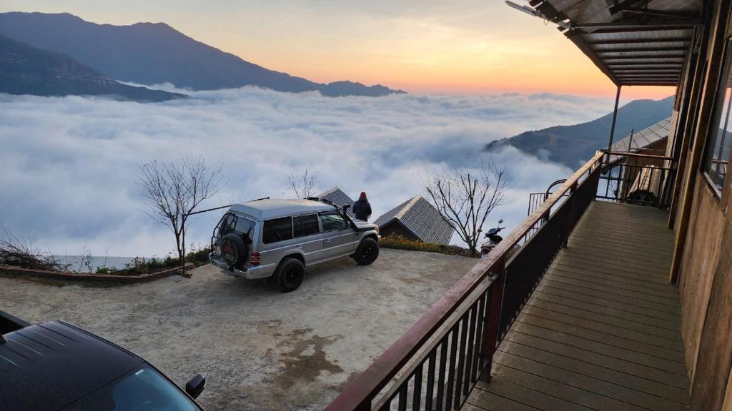 a car parked on the side of a house with clouds at Vừng Homestay - Taxua in Bắc Yên