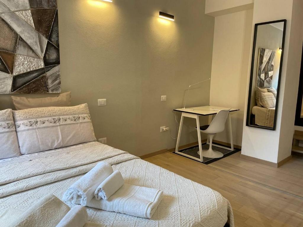- une chambre avec un lit, un bureau et un miroir dans l'établissement Il Gelsomino Notturno Modern Studio!, à Cagliari