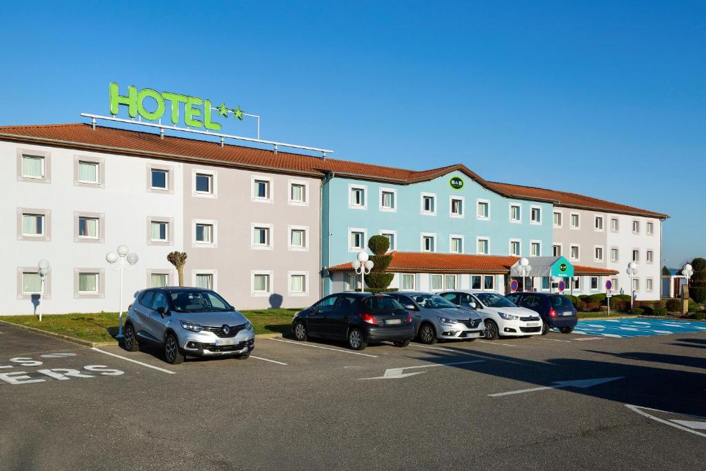 a hotel with cars parked in a parking lot at B&B HOTEL Mulhouse Kingersheim in Kingersheim