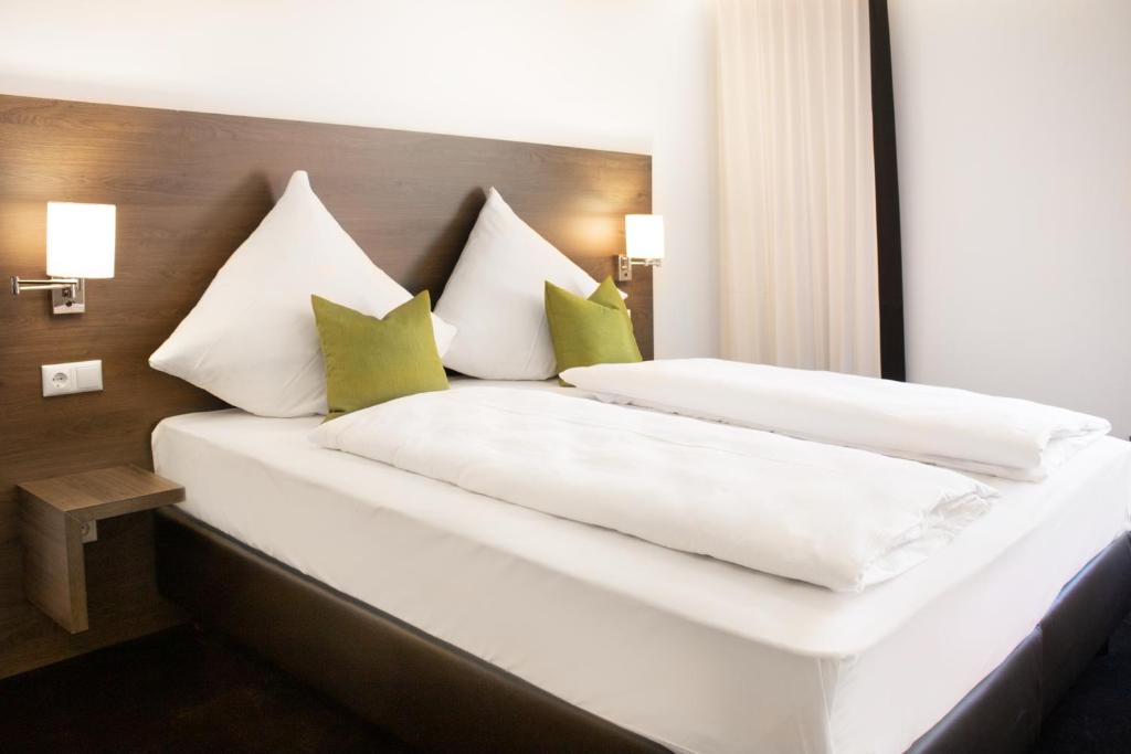 um quarto com 2 camas com almofadas verdes e brancas em MO Hotel by WMM Hotels em Ingolstadt