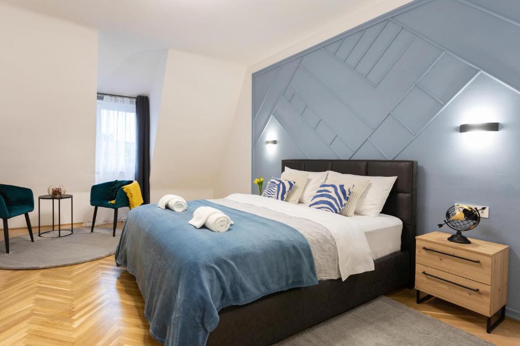 a bedroom with a large bed and a room with a table at Design 1BDR Loft near Kvaternik Square in Zagreb