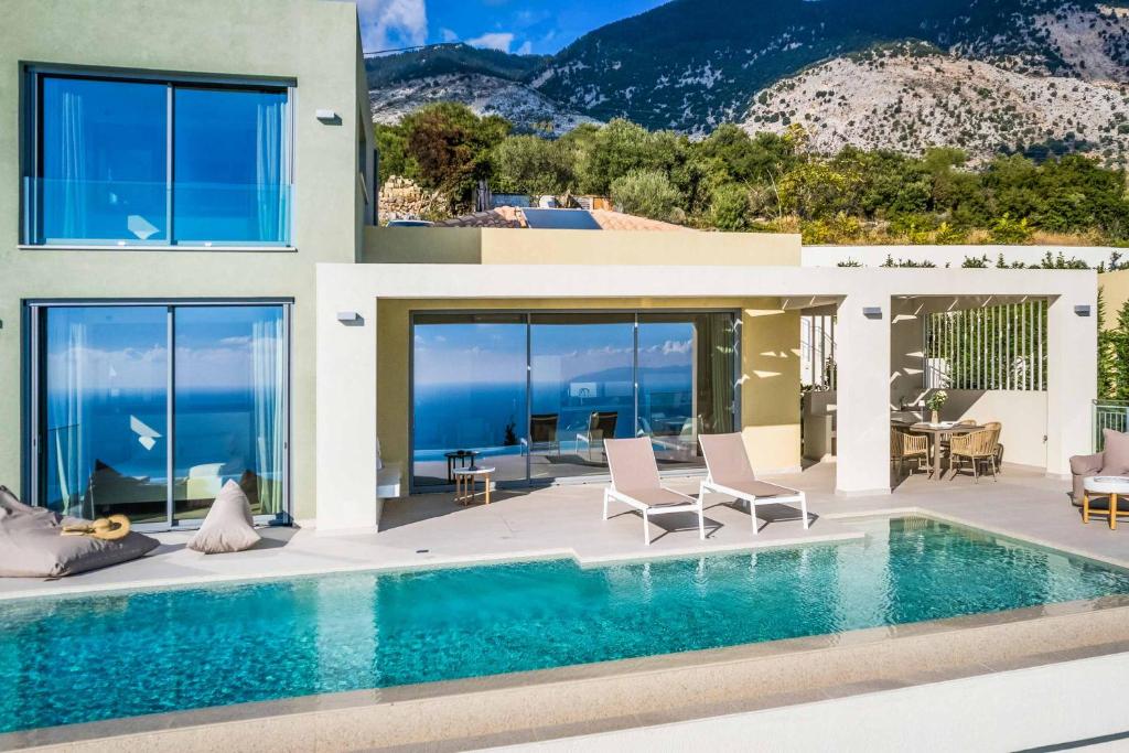 a house with a swimming pool with a view of the ocean at Villa Sorian Prasino in Vlachata